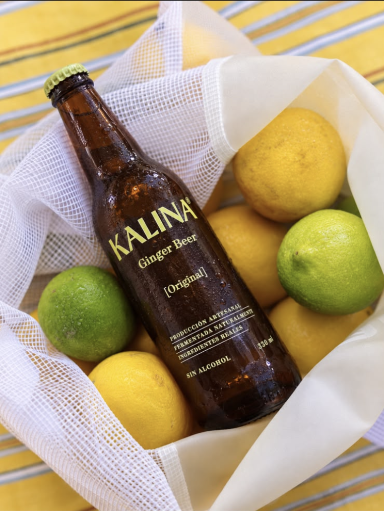 Botella de Kalina junto a limones frescos