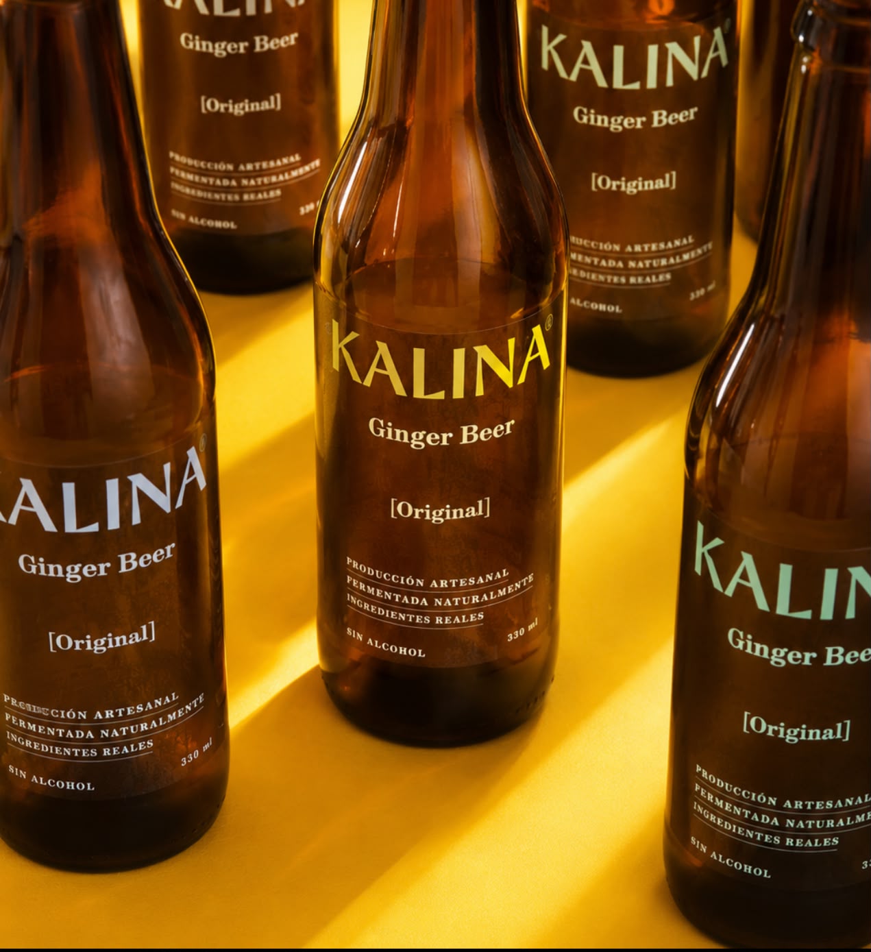 Botella de Kalina Ginger Beer entre limones y jengibre